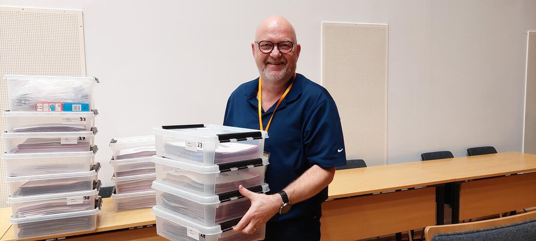 Smilende mann med stemmesedler i kasser