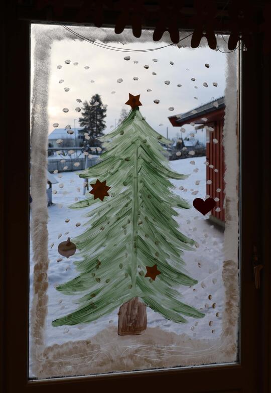juletre malt på vindu med snøprikker rundt
