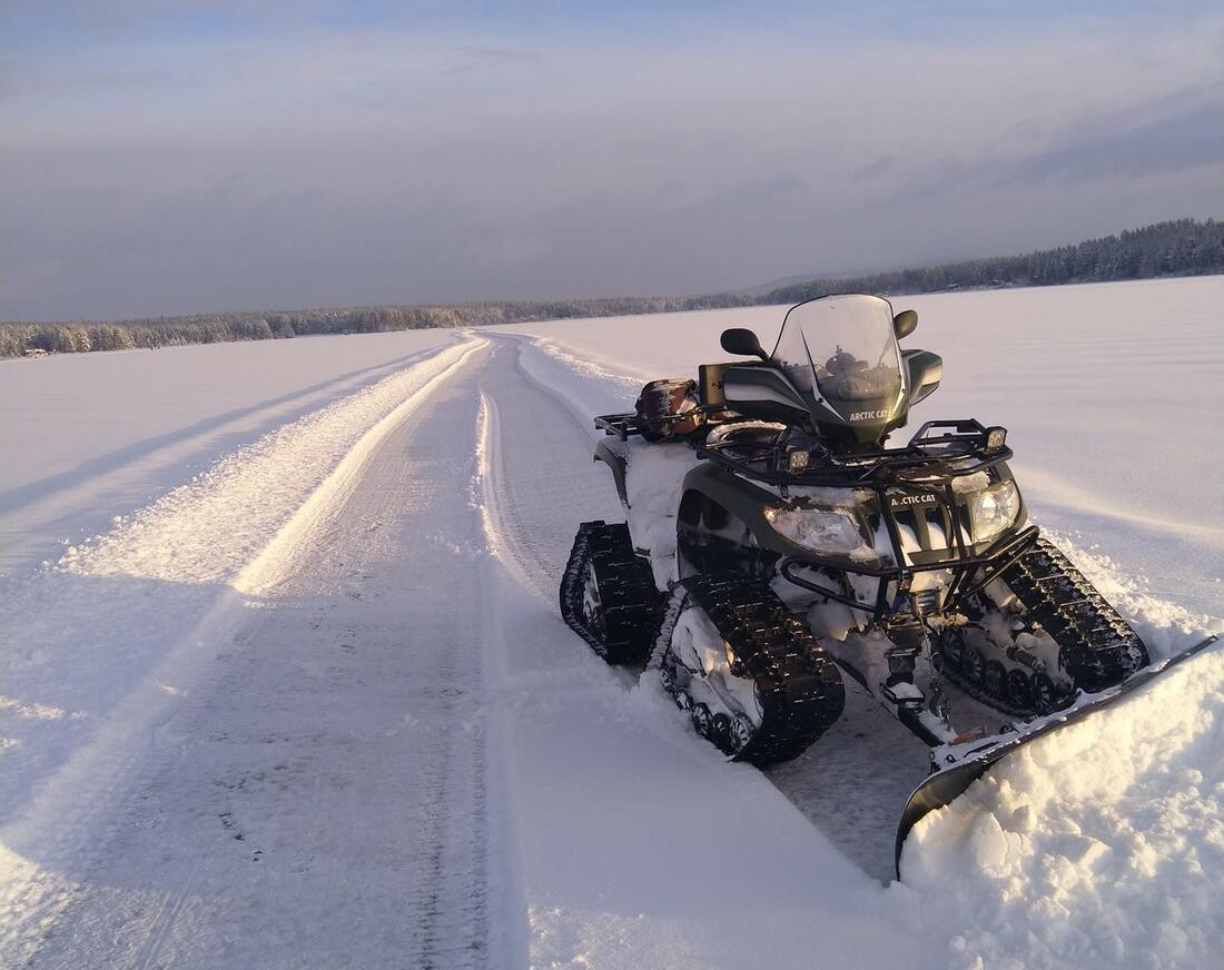 ATV som brøyter snø på islagt vann