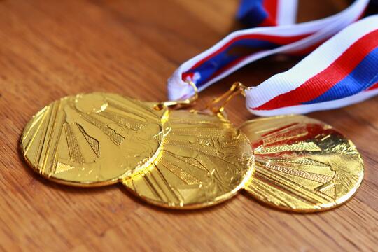 Bilde av gullmedaljer som ligger på en benk. 