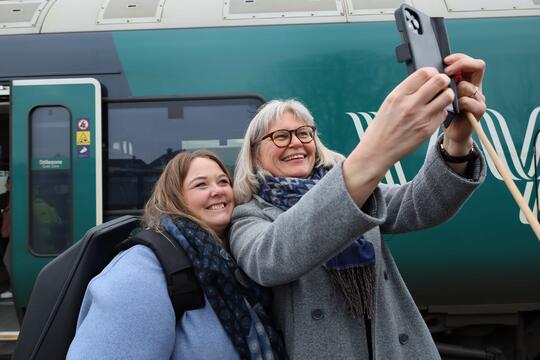 to damer som tar selfie foran tog