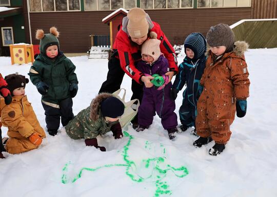 barn ute og lager maling i snøen